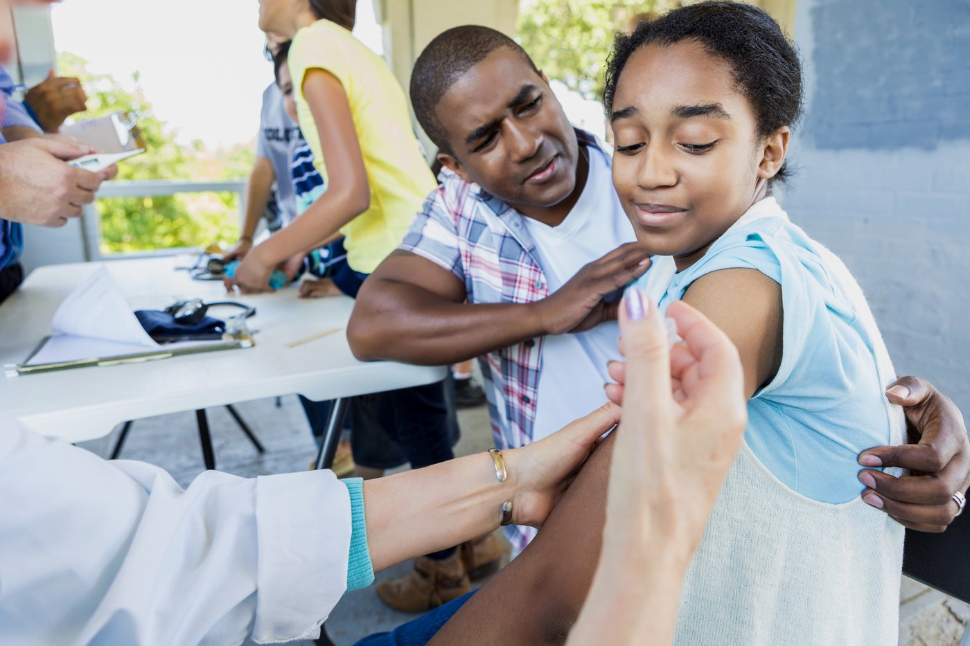 Teen receiving a vaccination with support from a parent